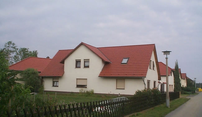 Reihe von Einfamilienhäusern mit roten Dächern in einer Siedlung, gebaut von Berthold - Bau aus Lauta.