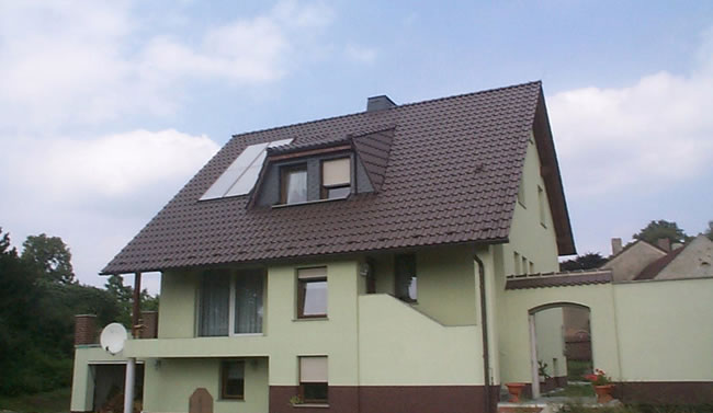 Großes Haus mit braunem Dach, Solarpanelen und Anbau, ein Projekt von Berthold - Bau aus Lauta.