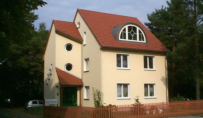 Individuelles Haus mit runden und halbmondförmigen Fenstern, gebaut von Berthold - Bau aus Lauta.