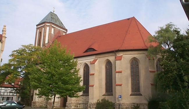 Historische Kirche mit rotem Dach und Turm, saniert durch Spezialisten wie Berthold - Bau aus Lauta.