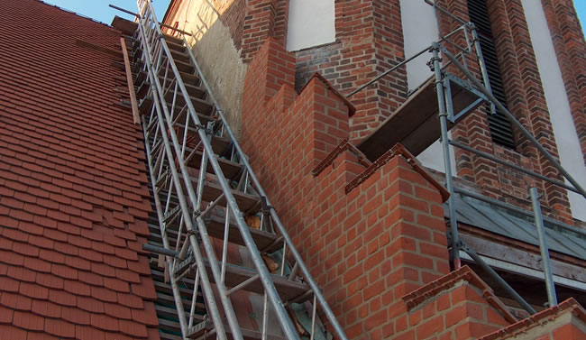 Kirchendach und Mauerwerk während der Sanierung mit Gerüst, ausgeführt von Berthold - Bau aus Lauta.
