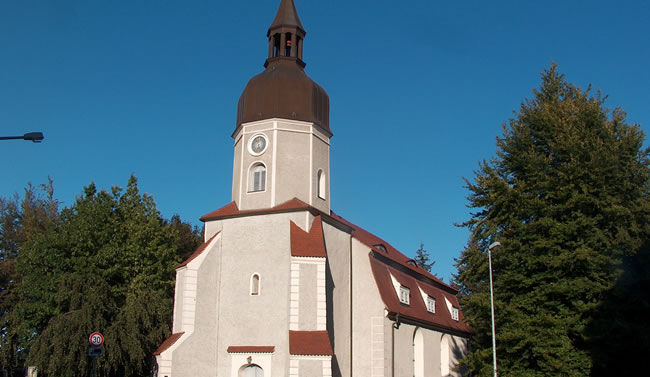 Evangelische Kirche in Lauta, saniert mit Expertise von Berthold - Bau, unter blauem Himmel.